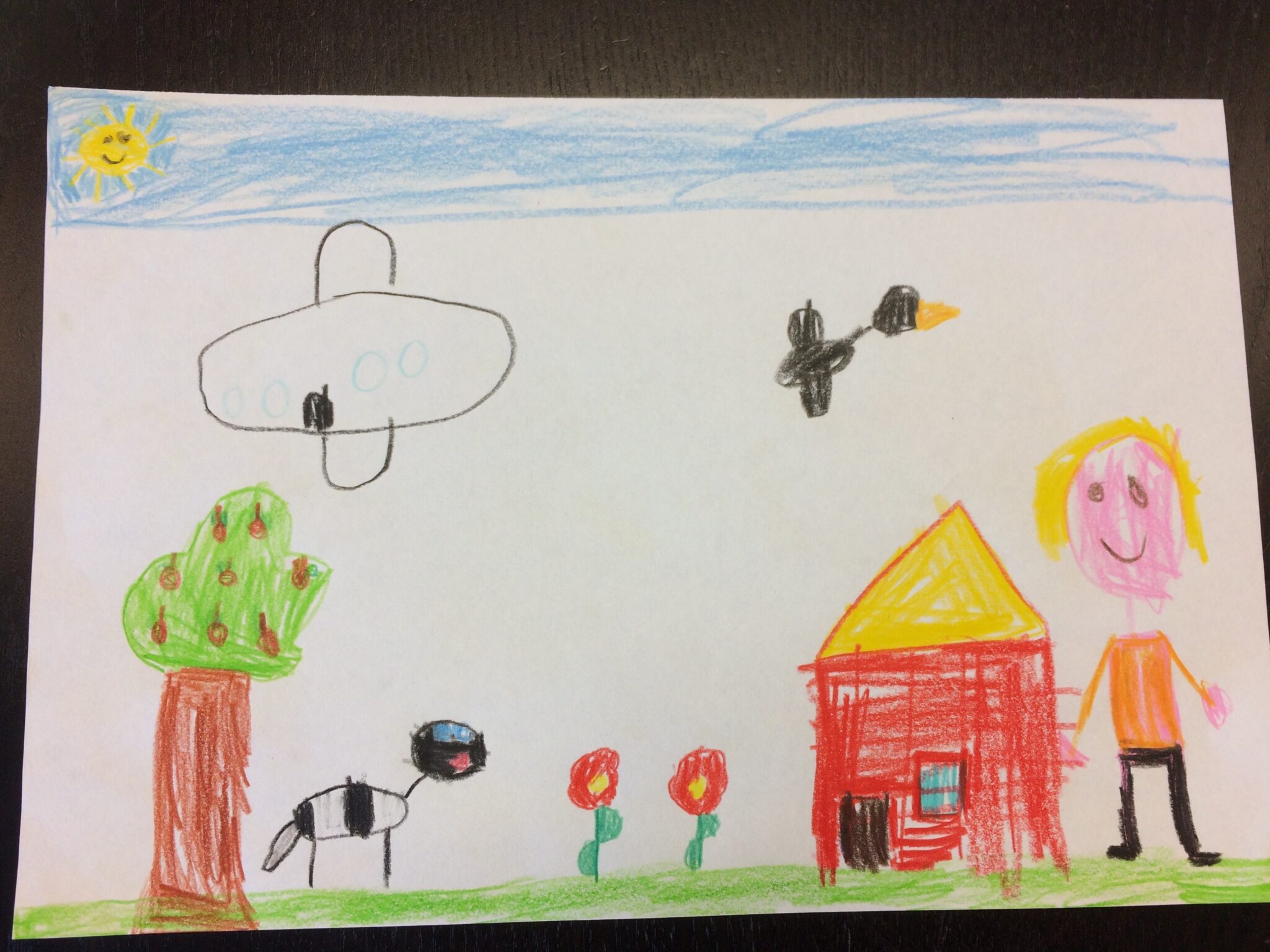 Original child drawing with a house, tree, flowers, sky and characters